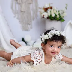 Such a cutie! This simple, elegant setup with a floral crown and a soft white rug lets this baby girl's natural charm shine through.