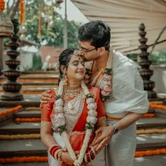 A tender kiss on the forehead, a blessing from the groom to his bride, surrounded by the beauty of their traditional wedding decor.