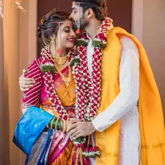 A gentle kiss on the forehead after the main rituals. We focus on these small, intimate gestures that are full of emotion, set against the vibrant colors of the bride's Paithani saree and the groom's simple kurta.