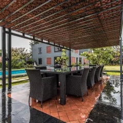 This outdoor dining pavilion is an extension of the home's living space. The structure, with its unique terracotta block roof, provides a comfortable and stylish area for enjoying the outdoors, protected from the elements.