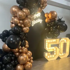 Another angle of the 50th milestone celebration decor. The lighting from the marquee numbers and neon sign creates a warm, celebratory glow, making it an excellent focal point for the event space.