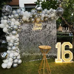 I create chic and modern setups perfect for a 16th birthday or any stylish celebration. This outdoor party features a stunning silver sequin wall for the perfect photo backdrop, a balloon arch with disco ball accents, and large glowing numbers to mark the special age.