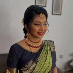 A happy client ready for the celebrations. Her makeup is kept fresh and radiant to complement her beautiful green and navy blue silk saree, ensuring she feels comfortable and gorgeous throughout the event.