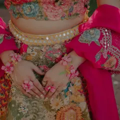 A close-up on the bride's hands, adorned with beautiful floral jewelry for her Haldi ceremony. These detail shots highlight the unique and personal touches of the wedding.