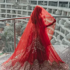 A classic bridal portrait with a dramatic red veil. The architecture of the Hotel Sahara Star provided a stunning modern backdrop for this timeless shot.