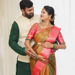 A beautiful portrait of the expecting couple, taken during their baby shower. They are dressed in festive traditional wear, smiling at each other, surrounded by the joy of the day.