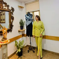 A photo from day one of my fashion styling workshop at the International College of Fashion. My lime green co-ord set with its creative construction stands next to a mannequin styled by one of the students.