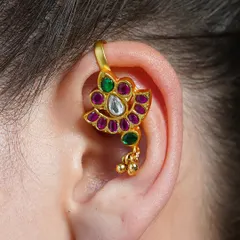 A close-up of our Alayaa earcuff, showcasing the intricate setting of polki, ruby, and emerald stones in a floral design.