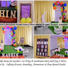 A "Twinkle Twinkle Little Star" theme for a first birthday. This setup includes a moon prop, cloud cutouts, and a colorful balloon garland against a simple curtain backdrop.