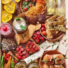 This is my signature grazing platter, available for delivery. It's a vibrant mix of flavours including Vada Pav, bruschetta, hummus, and falafel, perfect for a small party.