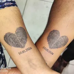 For a truly personal couple's tattoo, we used the clients' actual fingerprints to form two hearts. It's a unique way to show your connection, and I love working on these 'swalpa different' ideas that are special to you.