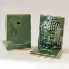 This view shows the thoughtful design of the Buddha tealight holder. You can see the rich green glaze and the small hole in the back, which allows you to easily hang it on a wall for a unique, candle-lit wall sconce effect.