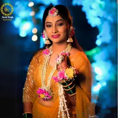 A modern bride's Haldi look. This jewellery set with pink and yellow flowers adds a fresh and contemporary touch to the ceremony.