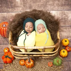 I specialize in newborn twin photography, and this autumn-themed setup is a client favorite. Here, two sleeping twins are swaddled snugly in a wicker basket, surrounded by colorful pumpkins and fall foliage.