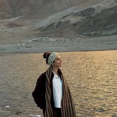 A quiet moment by a high-altitude lake in Ladakh as the sun sets. The crisp air and the golden light on the water create a feeling of profound peace and connection to the earth.
