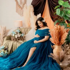 A dreamy, boho-chic setup featuring a mom-to-be in a magnificent blue tulle gown. The pampas grass, soft lighting, and layers of fabric create a whimsical and romantic feel.