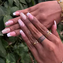 A timeless bridal look combining a classic French manicure with delicate 3D floral sculptures and glitter accents. This set of acrylic extensions shows how we can blend classic elegance with personalized art for your special day.
