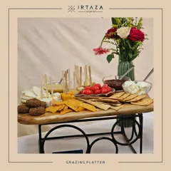 Another style of grazing platter for a corporate gathering. This one features a variety of dips, cheeses, and crackers, elegantly arranged with a floral centerpiece.