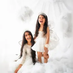Pure, unfiltered joy. My dreamy clouds setup is a favorite for kids' photoshoots, and these sisters brought all the happy energy. Capturing genuine laughter like this is my absolute favorite part of being a children's photographer.