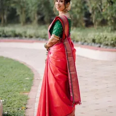 A beautiful shot showcasing the back and the elegant fall of the Paithani saree. The pre-set pleats ensure the drape remains flawless from every angle.