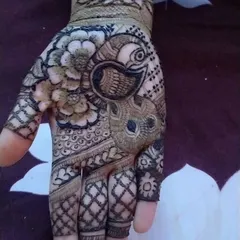 Another example of a peacock design, this time placed on the palm. It's surrounded by floral and geometric patterns, making it a beautiful focal point.
