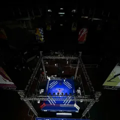 A dramatic top-down view of the boxing ring set up for the Women's World Boxing Championships. This highlights how our space is transformed into a professional combat sports arena, focusing all attention on the action in the center.