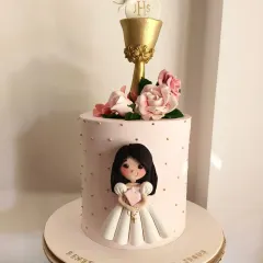 A First Holy Communion cake for a sweet girl named Renessme. This elegant pink cake is adorned with a hand-sculpted figurine, a golden chalice, and beautiful sugar roses. It was an honor to be chosen for such a special day.