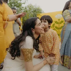 A sweet moment between the bride and a young family member at her Haldi. Her romantic look, an ivory saree with a gold sequin blouse, was inspired by vintage jazz and a modern 'gajrewali' vibe.