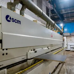 This industrial SCM machine applies edge banding to panels with extreme precision. This process protects the edges from moisture and impact, ensuring the longevity of your office workstations and furniture.