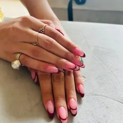 An elegant and "expensive" looking French manicure with a deep red, curved tip on a natural base. The almond shape of the nail enhances the graceful lines of the design.