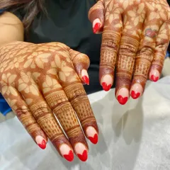 The perfect pairing of traditional and modern. We designed these nails with bright red, heart-shaped tips to beautifully accentuate the intricate and stunning mehendi art.