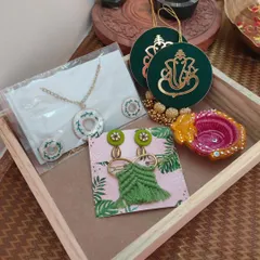 A mid-range Diwali hamper containing a Ganpati wall hanging, a necklace set, a decorative diya, earrings, and a hairpin. A perfect festive gift for friends and family.