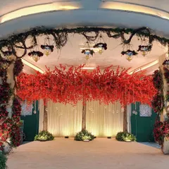 I designed this stage for a Navjote with a canopy of red foliage and hanging glass orbs. The design is modern yet respectful of tradition, creating an elegant backdrop for the ceremony.