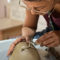 A close up of the trimming process, a quiet, focused moment that is a crucial part of the pottery journey.