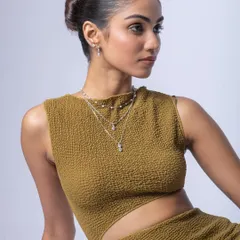 A profile shot for a jewelry campaign, highlighting the layered necklaces and earrings. The lighting is bright and even to showcase the product details.