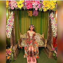 Here is a happy bride during her Mehandi ceremony, sitting on a traditionally decorated swing. I used bright, multi-colored gerbera daisies and other flowers to frame the jhula and match her festive attire.