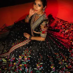 I designed this black lehenga to be captivating and eye-catching. The vibrant, multicolored floral embroidery pops against the dark base, and the sheer embroidered sleeves on the blouse add a touch of modern elegance.