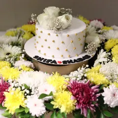 We love making celebrations extra special with our floral platters. Here, we created a vibrant ring of fresh yellow, white, and purple chrysanthemums to frame an elegant white cake for a Nikah ceremony, with the couple's names displayed at the base.