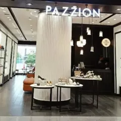 A slightly different angle of the Pazzion storefront, highlighting the central fluted column and pendant lighting feature that serves as a focal point.