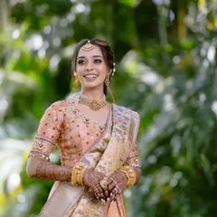 Bathed in blessings and glowing with happiness. This bride is radiant in her peach-toned South Indian outfit, with soft, luminous makeup and a beautiful, happy smile.