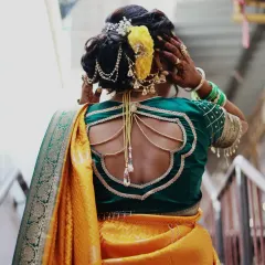The back of the blouse and the hairstyle are key parts of the look. This photo shows a stylish blouse design and an intricate bun with floral and jewelry accents.