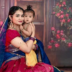 A beautiful portrait of a mother holding her baby, both dressed in stunning traditional outfits for our Krishna Janmashtami themed shoot. The baby's curious look is just precious.