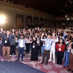 A wide shot of the audience at the UXINDIA conference participating in an interactive activity. This image powerfully conveys the energy and collective engagement of the attendees.