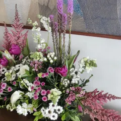 A close-up of a modern floral bouquet. The mix of textures, from the feathery pink astilbe to the spiky purple liatris and delicate daisies, creates a visually interesting and artistic composition.