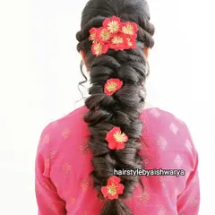 A beautiful and voluminous messy braid. I added red floral clips throughout the braid to add a pop of color and texture, making it perfect for a festive occasion.