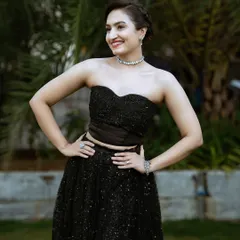 A modern and chic black two-piece ensemble with a strapless corset top and a sparkling sequined lehenga skirt.