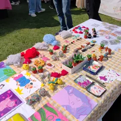 Another angle of my stall, showing how I arrange my crochet art and illustrated goods. The display includes tiny crochet cacti, plush animals, and colorful art prints, creating a vibrant and inviting setup for visitors.