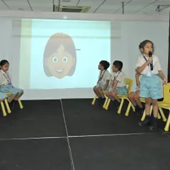A young learner presents her answer during a language competition. These events are designed to sharpen listening and spelling skills in a supportive and encouraging environment.