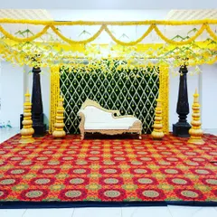 A traditional mantap setup with four pillars and a canopy of marigold garlands, ready for a ceremony.