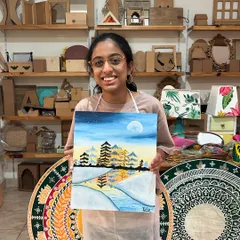A smiling artist with her finished misty pine tree painting. This landscape workshop is a great way to connect with nature and create a beautiful piece of art for your home.